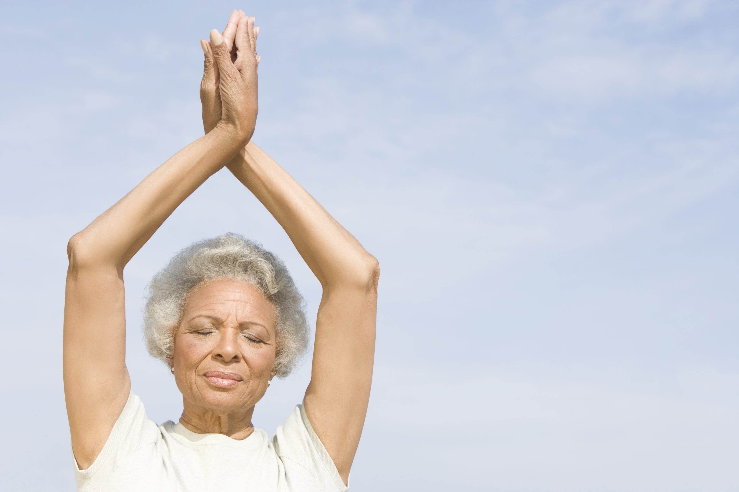 An elderly woman meditating.