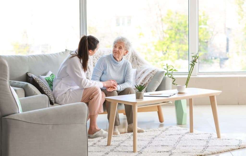 An lderly woman receiving compassionate care in a comfortable nursing home.